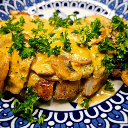 juicy-pork-chops-in-creamy-mushroom-sauce-served-with-herbs